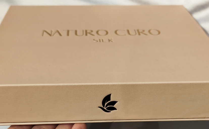 Premium beige gift box with NATURO CURO branding and embossed leaf logo for silk pillowcase set