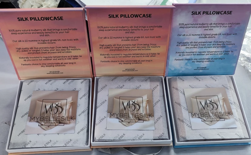 Open MYBELLESILK silk pillowcase gift boxes showing product cards and packaging design