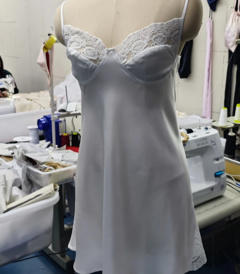 White silk slip dress with lace trim on mannequin