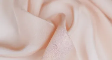 Blush pink silk chiffon fabric close-up with airy texture