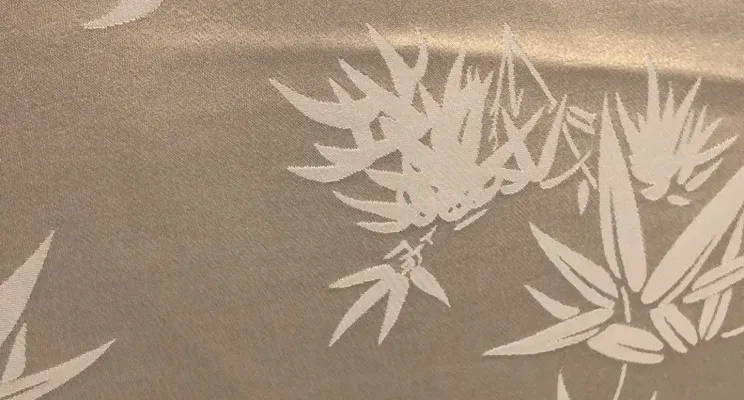 Gold silk jacquard fabric close-up with metallic woven design
