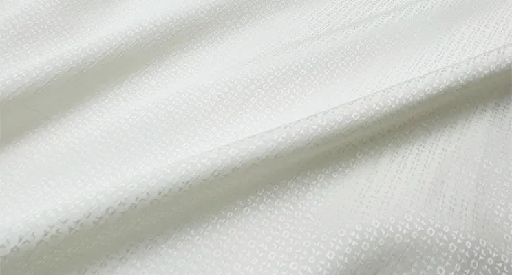 White silk jacquard fabric showing woven pattern texture