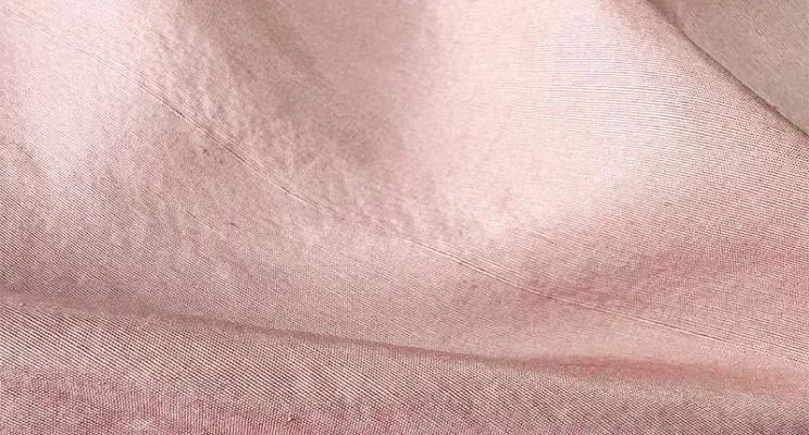 Pink silk dupioni fabric close-up with visible slubs