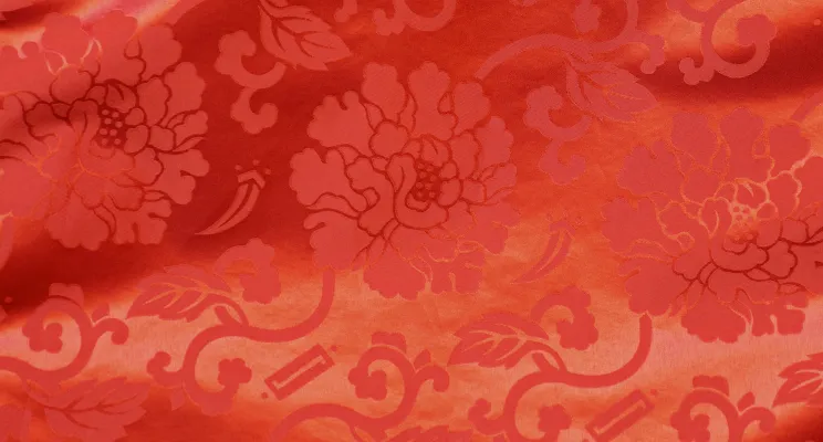 Red silk jacquard fabric swatch with rich woven texture