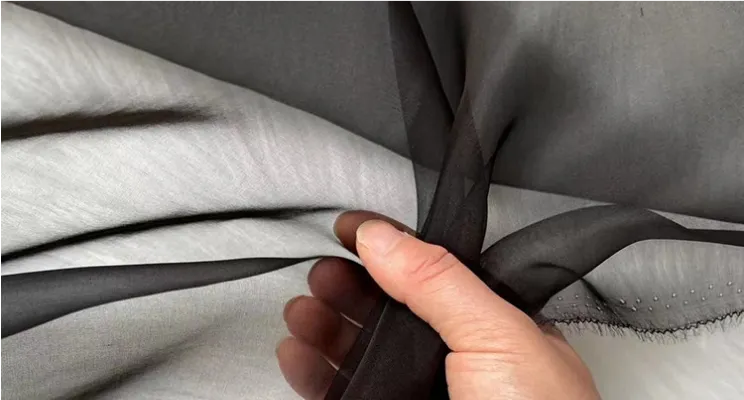 Black silk organza fabric close-up with structured sheen